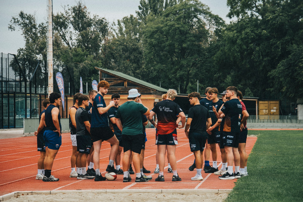 Group of athletes receiving coaching on an outdoor track