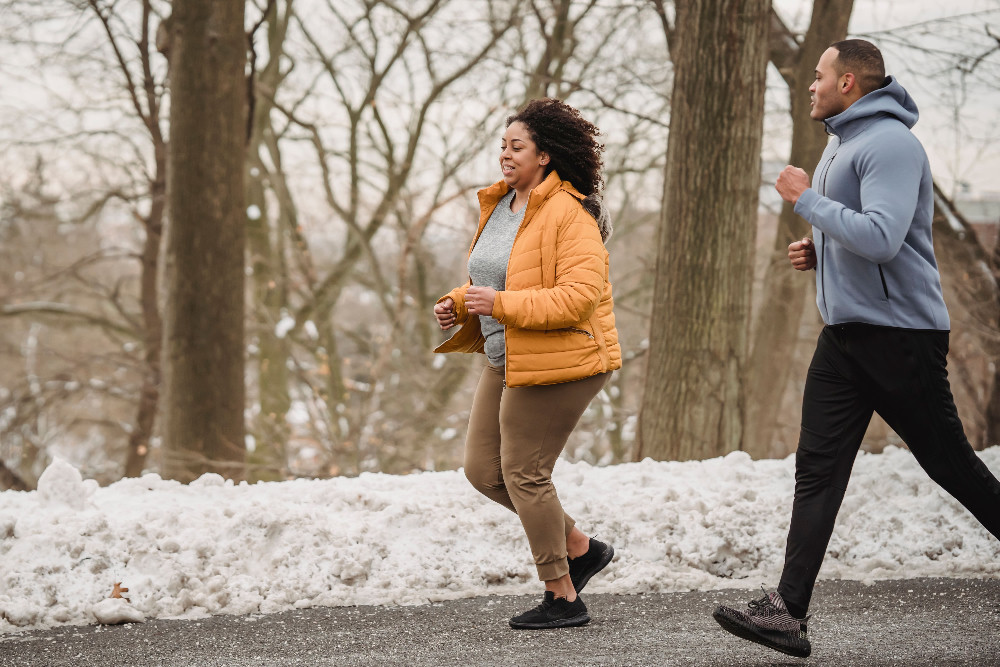 Coach running with athlete during an outdoor session